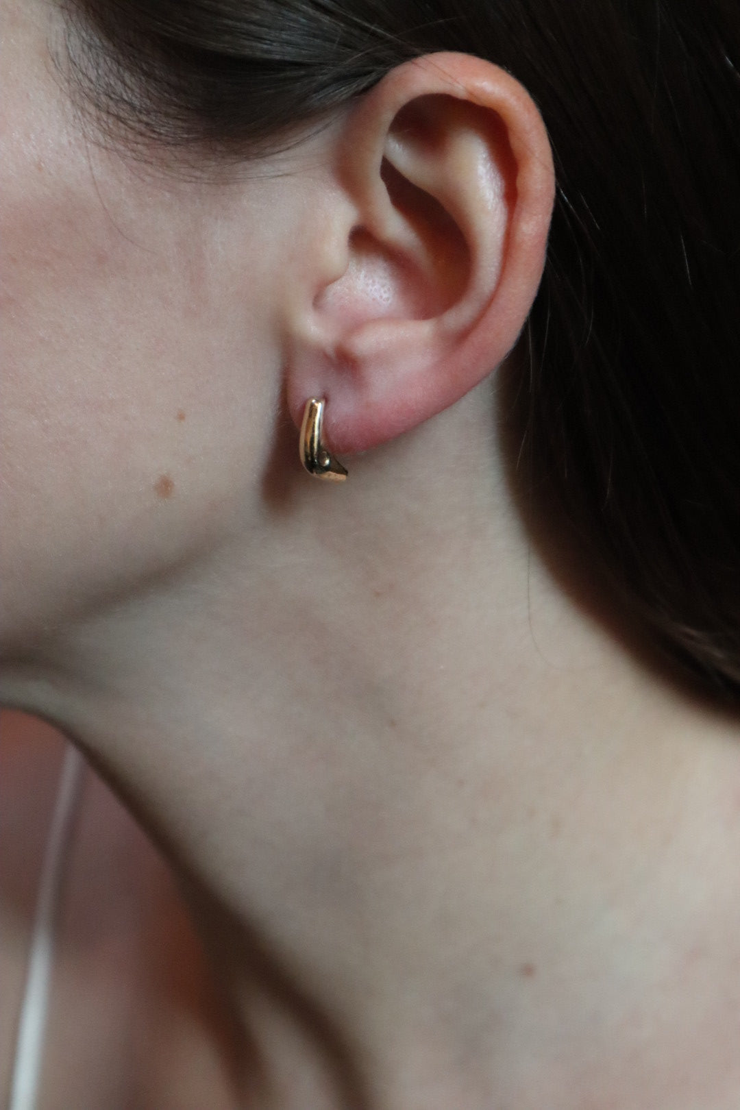 Close-up of an ear with a gold earring